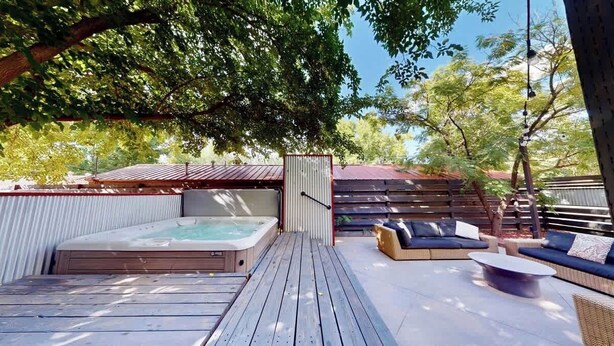 A wooden deck with a hot tub, outdoor seating, and a fenced area. - Moab Flats - 5, Mid Century Modern on Main (Moab)