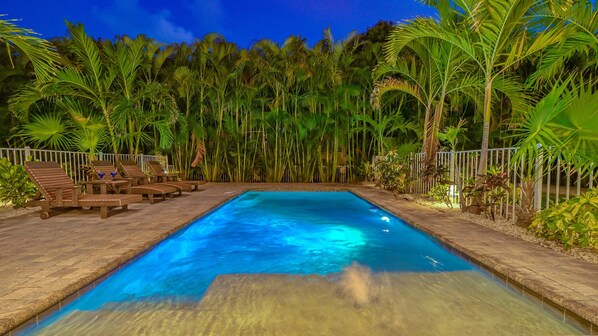 Une piscine rectangulaire à l’eau d’un bleu limpide, entourée d’une terrasse dallée.