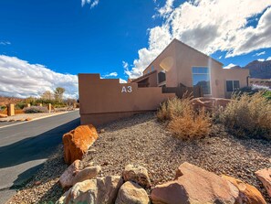 A modern building with a flat roof, labeled 'A3,' situated in a desert-like environment with a clear sky and scattered clouds. - Arches Abode - A3, 3 Bedroom Condo in Moab and Beautiful Views (Moab)