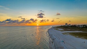 A beach with a sunset, a sandy shore, and buildings in the background. - Casa Mahalo | Pet Friendly, Ping Pong Table, Private Heated Pool, Steps to Beach! (Siesta Key)