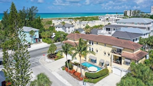 A coastal residential area with a large house featuring a swimming pool, surrounded by lush greenery and a clear view of the ocean. - 🦋 Casa De Mariposa | Heated Pool, Gulf Views, Dual-Villa Duplex, Walk to Siesta Key Beach (Siesta Key)
