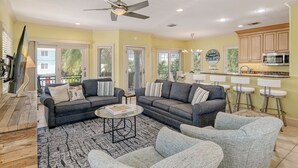 A spacious living room with two sofas, a coffee table, and a ceiling fan.