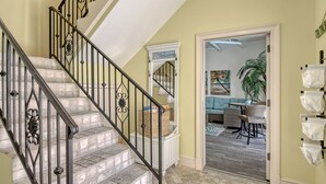 A staircase with black railings leading to a landing with a 'Welcome' sign.