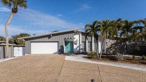 A modern two-story house with a garage, a driveway, and a well-maintained lawn. - Villa De Paradisio | Waterfront Home w/ Private Pool, Fishing Dock, Close to Beach & Village! (Siesta Key)