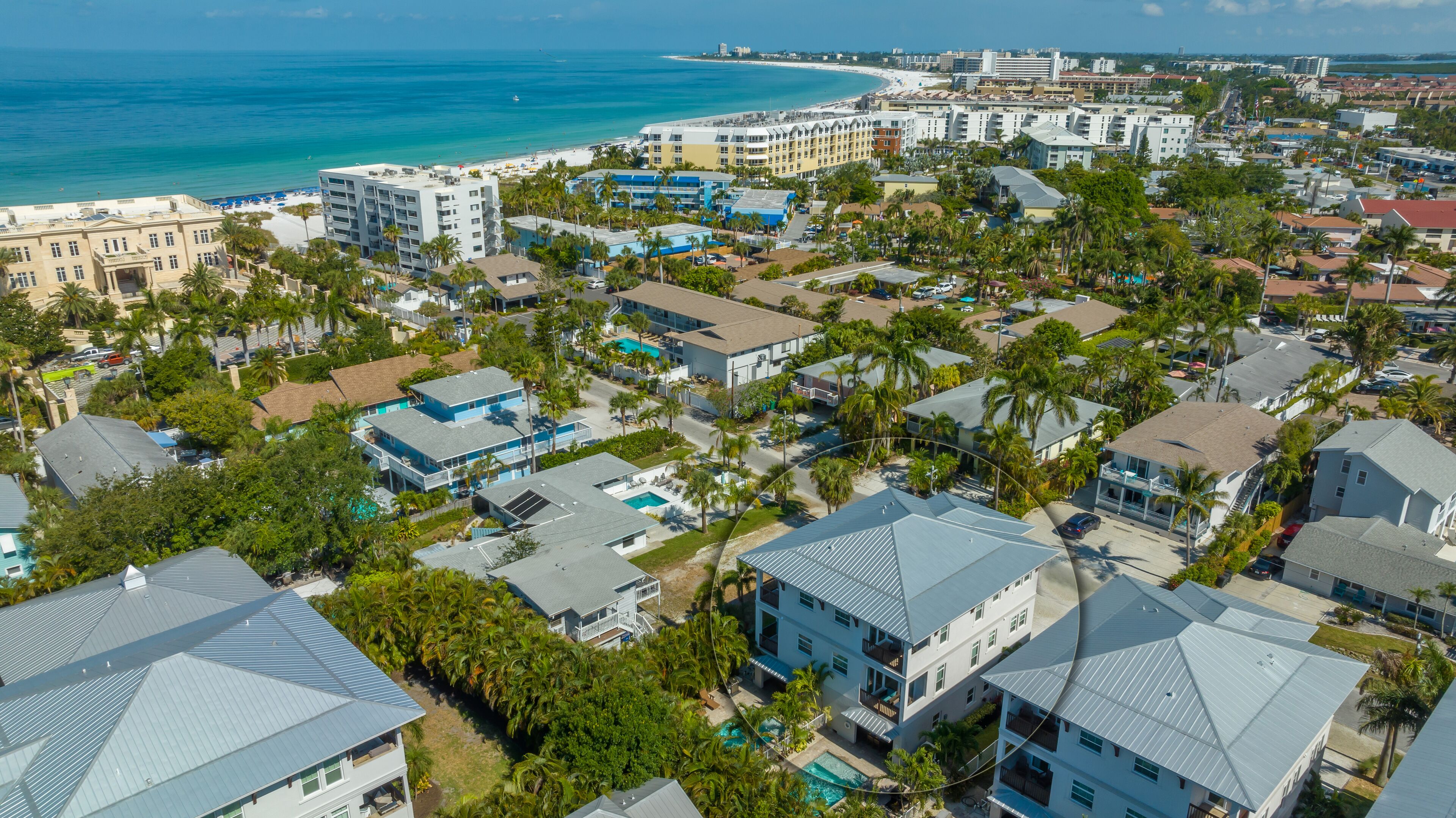 Una zona residenziale sulla costa con edifici a più piani, una spiaggia e una vista limpida sull'oceano.