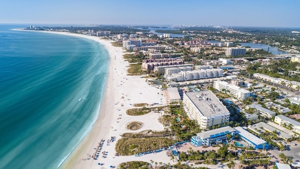 An aerial view of a coastal city with a wide beach, beachfront hotels, and a marina. - 🌴 Sol Y Mar | Private Duplex - Two Casitas, Walk to Siesta Keys Crescent Beach, HOA Pool (Siesta Key)