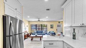 A modern kitchen with white cabinets, a stainless steel refrigerator, and a marble countertop. - 🌴 Sol Y Mar | Private Duplex - Two Casitas, Walk to Siesta Keys Crescent Beach, HOA Pool (Siesta Key)