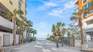 A coastal street lined with palm trees and buildings, leading to a beach. - 🌴 Sol Y Mar | Private Duplex - Two Casitas, Walk to Siesta Keys Crescent Beach, HOA Pool (Siesta Key)