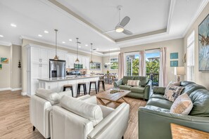 A spacious living area with a kitchen, a dining area, and a seating area with a view of the outdoors.