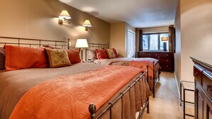 Ein Hotelzimmer mit zwei Betten, einem Schminktisch und einem Fenster mit Vorhängen.