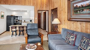 A cozy living room with a gray sofa, a wooden coffee table, and a fireplace. - Vail top-floor Condo, Pool, Hot Tub | W403 (Vail)