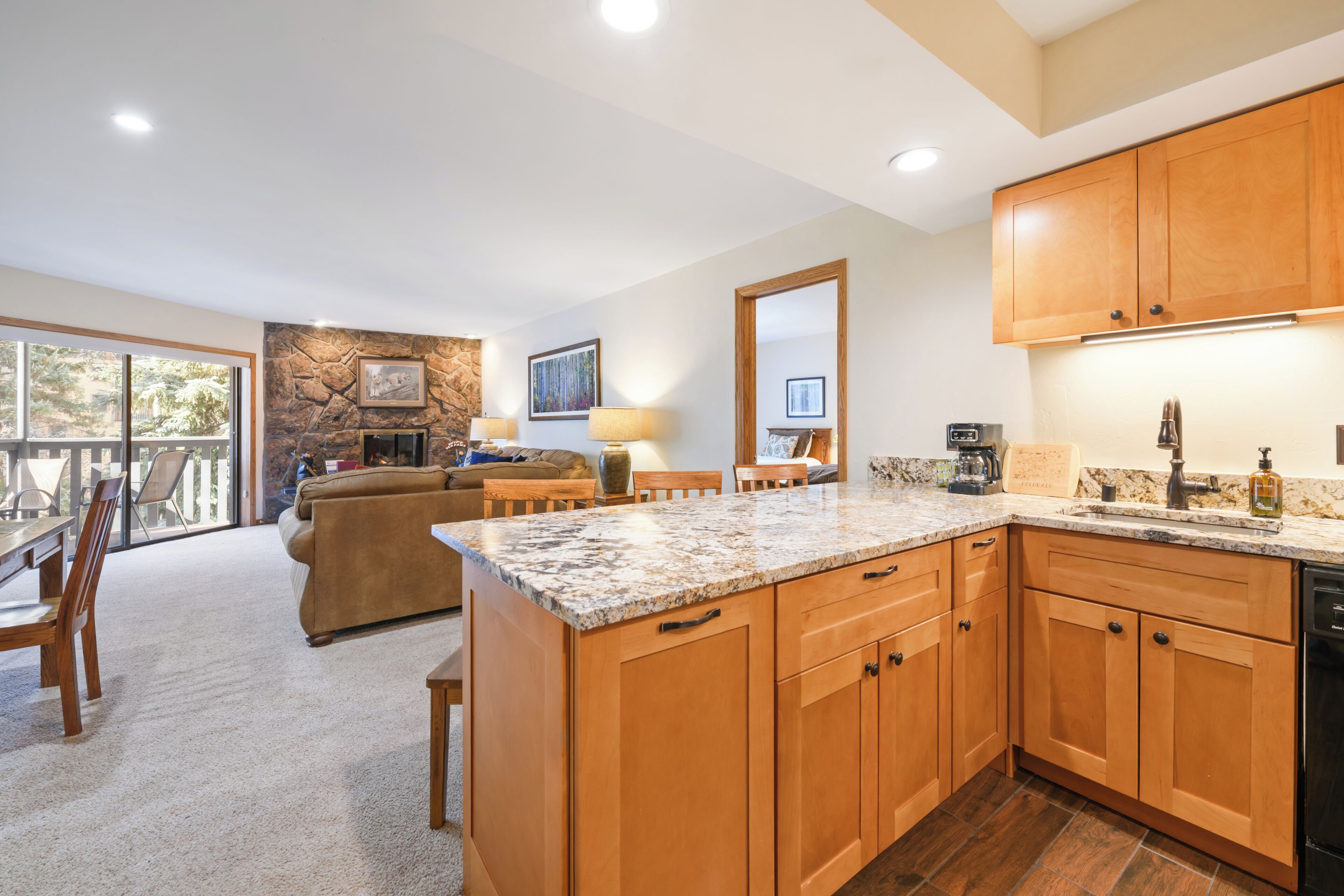 A spacious kitchen with wooden cabinets, granite countertops, and a built-in dishwasher.