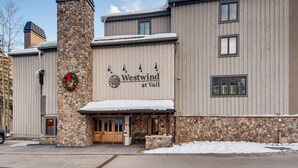 A building with a stone facade and a sign reading "Westwind at Vail." - Ski-lodge hotel room Lionshead Village | W306B (Vail)