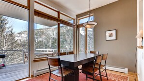 A dining area with a large table, chairs, and a view of a snowy landscape through large windows. - Views, Bright Spacious Vail Villa, SAV4B (Vail)