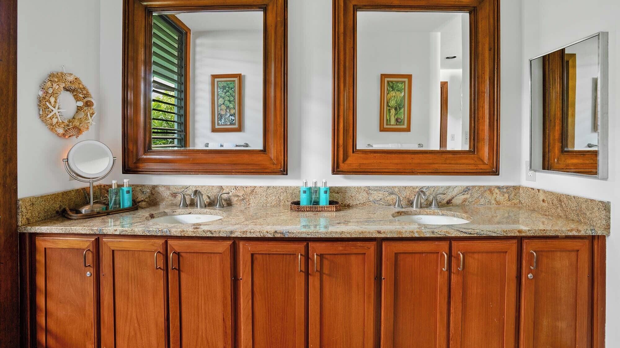 A bathroom with two sinks, wooden cabinets, and large mirrors.