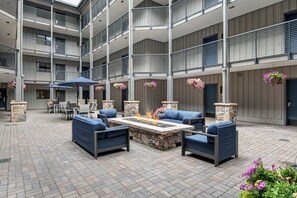 A multi-level outdoor patio with seating, a fire feature, and hanging flower baskets. - Remodeled Condo Vail Mtn Views | W201 (Vail)