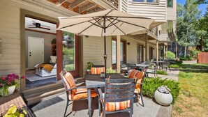 An outdoor patio with a table and chairs, a ceiling fan, and a covered seating area. - Western Way | Patio Facing Mountains & River (Telluride)