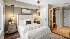 A bedroom with a bed, bedside tables, a ceiling fan, and a wardrobe. - Western Way | Patio Facing Mountains & River (Telluride)