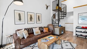 A modern living room with a brown leather sofa, a wooden coffee table, and a black floor lamp.