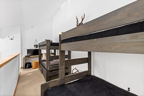 Habitación con literas, un escritorio y una televisión.