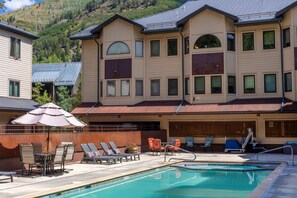 Un hôtel doté d’une piscine, d’un espace extérieur aménagé et offrant une vue sur un paysage montagneux.