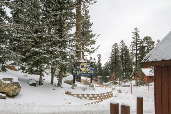A snow-covered landscape with a sign for the Ski & Racquet Club. - Mammoth Ski & Racquet Club #62 - Newly Renovated 2025 (Mammoth Lakes)