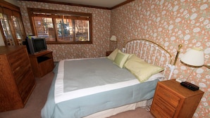 A bedroom with a bed, dresser, TV, and window. - Mountainback #60, Corner Unit (Mammoth Lakes)