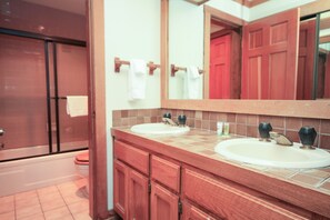 Un bagno con due lavabi, uno specchio grande e uno spazio doccia.