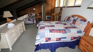 Ein Schlafzimmer mit einem großen Bett, einem Schminktisch, einem Schreibtisch und einem Spiegel.