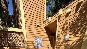 A wooden deck with a hot tub, surrounded by wooden walls with various signs, including a caution sign and a no food sign. - 107 McCloud 2BR/2BA Incline Village w/ Hot Tub (Incline Village)