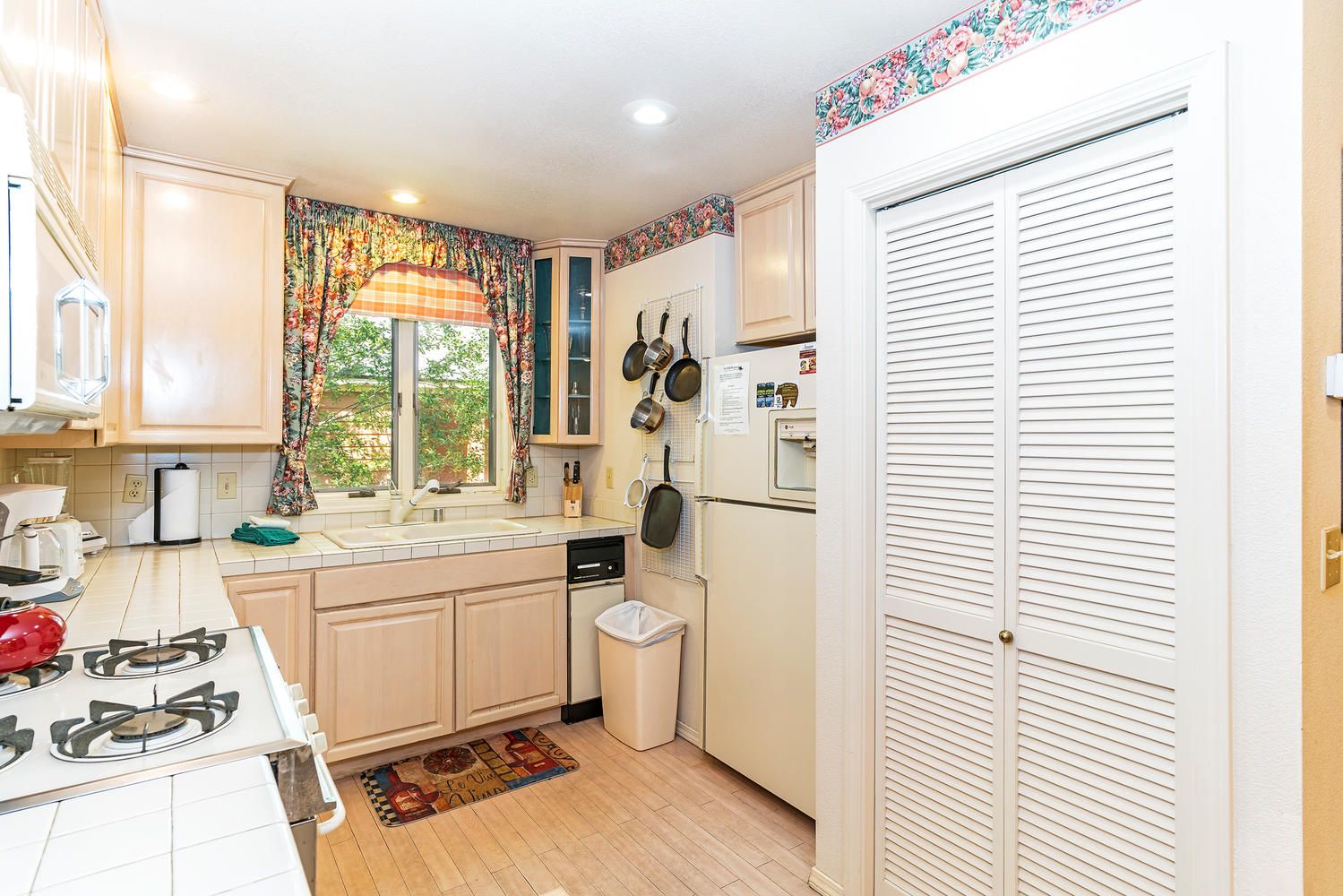 A compact kitchen with a gas stove, a dishwasher, and a refrigerator.