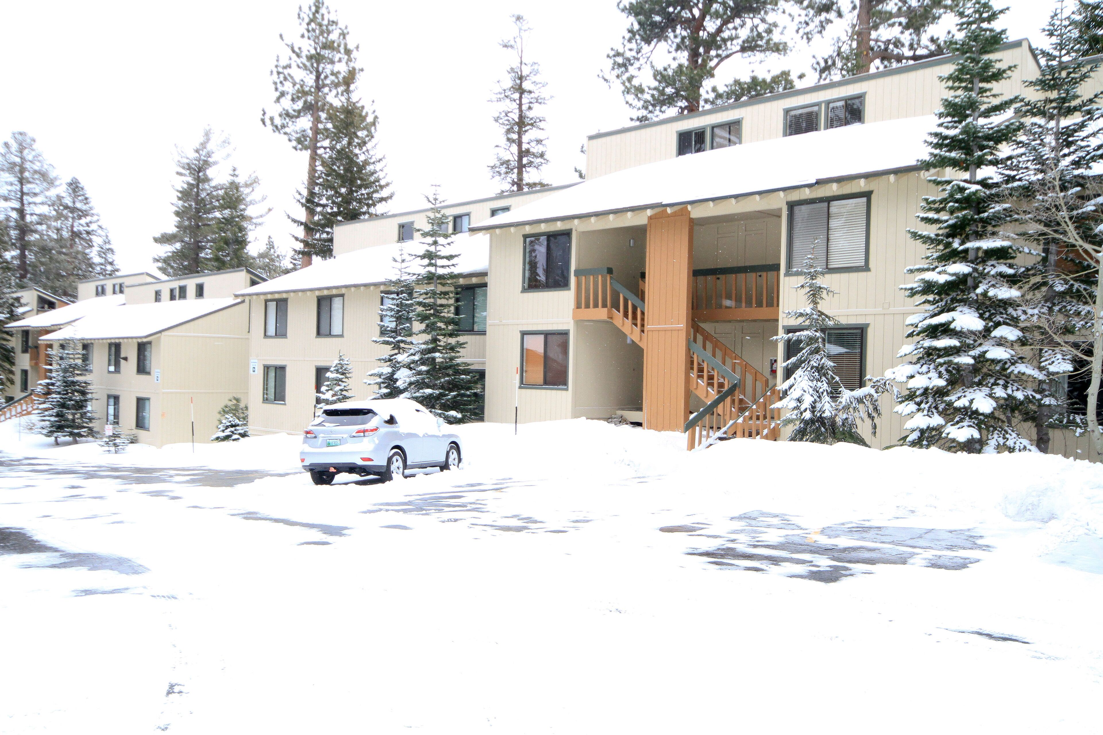 A multi-story building with a covered outdoor area and a staircase leading to the upper floor.