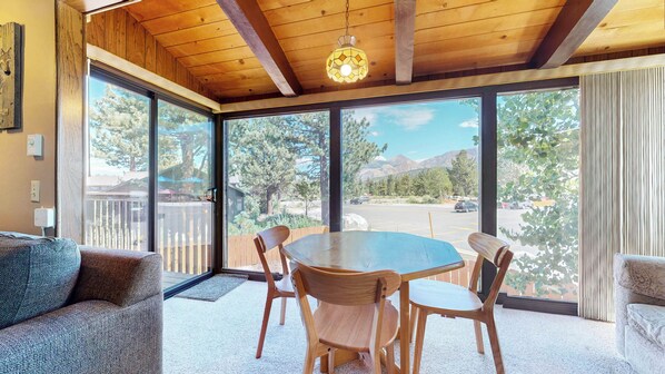 Relax in this inviting room with a large table, comfortable seating, and stunning views of the surrounding mountains.