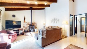 Ein gemütliches Wohnzimmer mit Kamin, Fernseher und bequemen Sitzmöglichkeiten.