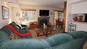 Una sala de estar con chimenea, televisor y comedor.