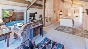 A spacious living area with a fireplace, a television, and a dining area with a kitchen in the background. - 10NSE | 3BR/2.5BA Incline Village, Mtn Views & BBQ (Incline Village)