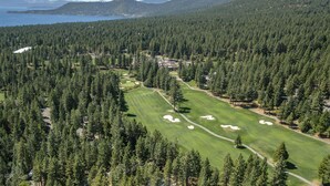 An aerial view of a golf course surrounded by dense forests and mountains. - 10NSE | 3BR/2.5BA Incline Village, Mtn Views & BBQ (Incline Village)