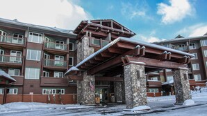 Un hôtel à plusieurs étages, doté d’une façade en pierre et de balcons en bois.