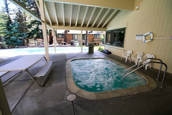 Relax by the pool with a hot tub and comfortable seating area.
