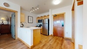 Una cocina moderna con armarios de madera, un refrigerador de acero inoxidable y un microondas empotrado.