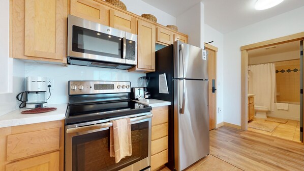 Enjoy cooking in this well-equipped kitchen with a microwave, oven, and refrigerator. The adjacent bathroom offers a shower and toilet.
