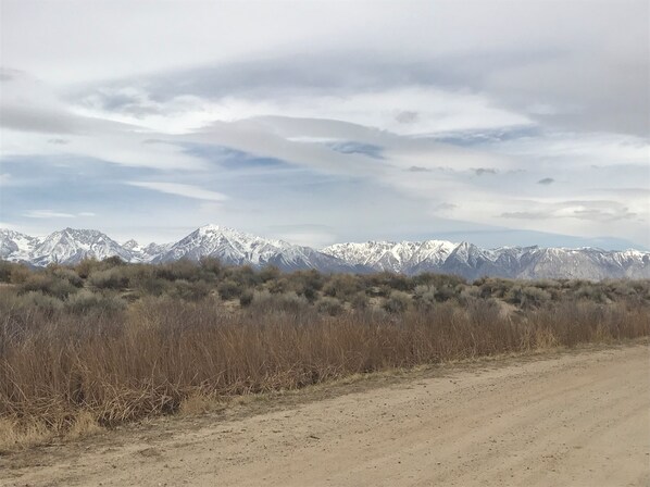 A dirt road leading to a mountainous landscape with sparse vegetation. - Mountainback #37, Den (Mammoth Lakes)