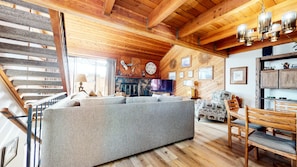 Relax in this inviting living area with a comfortable sofa, dining table, and fireplace.