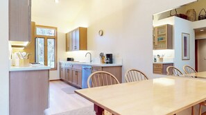 Eine moderne Küche mit Holzausziehtisch und -stühlen.