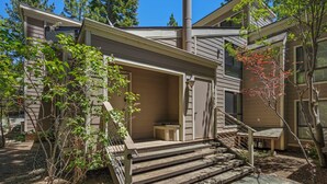 A two-story house with a chimney, a covered porch, and a small outdoor seating area. - 214 Forest Pine | 4BR/2BA Incline Village | Pool (Incline Village)