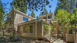 A two-story building with a stone pathway leading to a wooden staircase. - 214 Forest Pine | 4BR/2BA Incline Village | Pool (Incline Village)