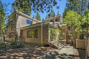 A two-story building with a stone pathway leading to a wooden staircase. - 214 Forest Pine | 4BR/2BA Incline Village | Pool (Incline Village)