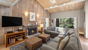 A cozy living room with a fireplace, a large flat-screen TV, and a comfortable sofa. - 214 Forest Pine | 4BR/2BA Incline Village | Pool (Incline Village)