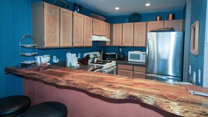A kitchen with wooden cabinets, a stainless steel refrigerator, and a wooden island with stools. - Mammoth Ski & Racquet Club #94, 2 bedroom Dog Friendly (Mammoth Lakes)