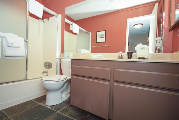 A bathroom with a toilet, shower, and vanity with a mirror. - Mammoth Ski & Racquet Club #94, 2 bedroom Dog Friendly (Mammoth Lakes)